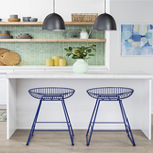 Two blue metal stools under a white kitchen island bar. 